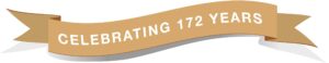172 Anniversary Banner A tan ribbon banner with white text that reads CELEBRATING 172 YEARS, slightly curved and casting a gray shadow underneath.