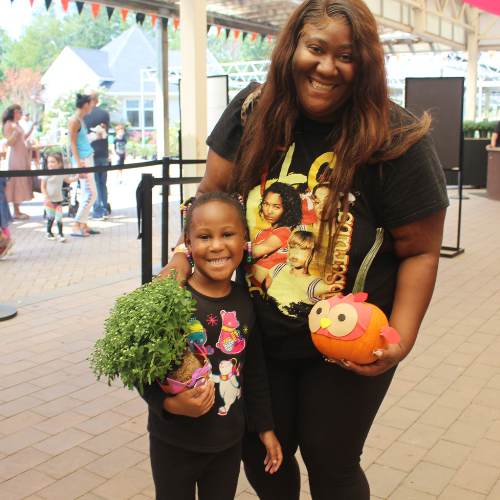 Hicks Nurseries Fall Festival (2) A woman and a girl holding pumpkins.