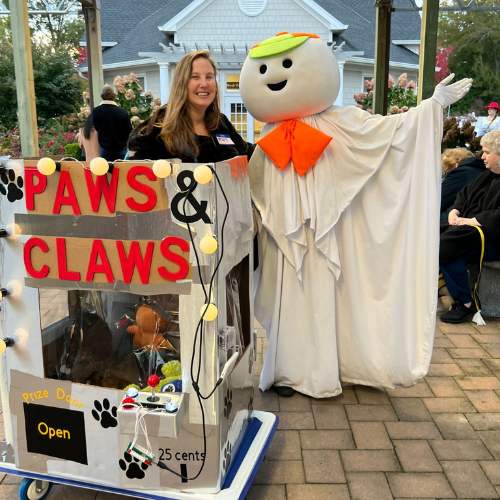Hicks Nurseries Pet Parade (3) A woman and her dog are dressed up for Halloween as the Paws and Claws game with a life sized Otto the Ghost at Hicks Nurseries Annual Pet Parade